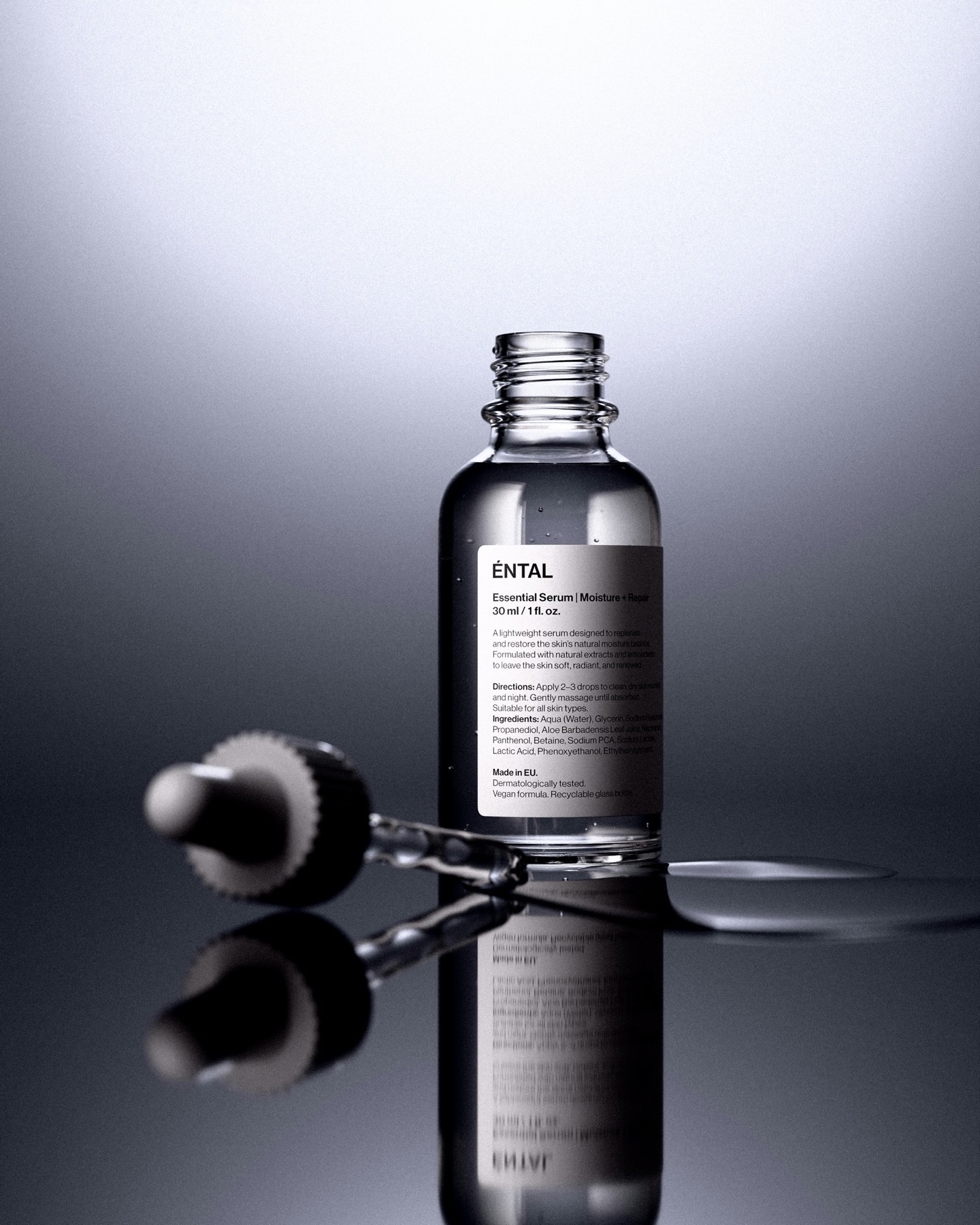 반사되는 표면 위에 놓인 스킨케어 세럼 병