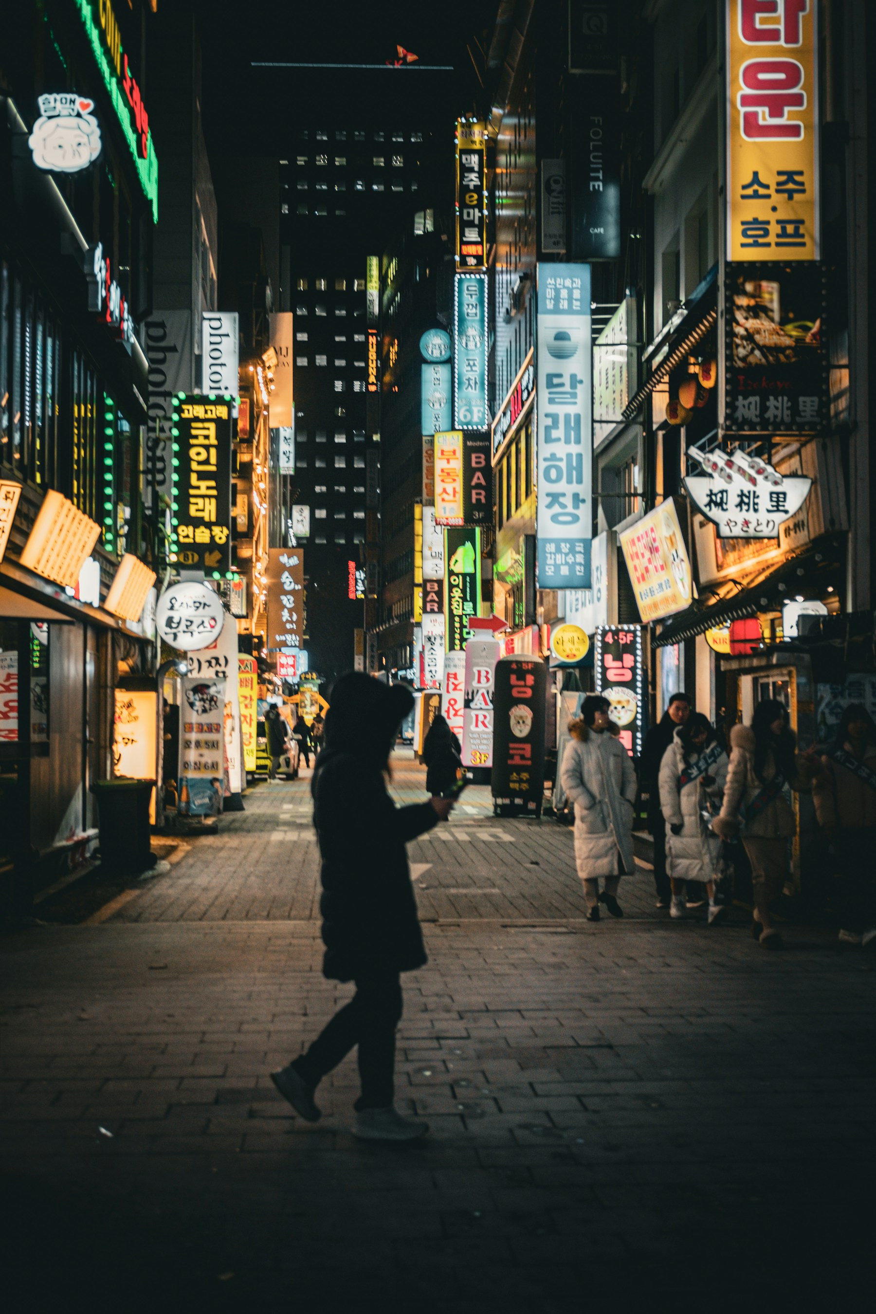 밤의 종로 거리에서 걷는 사람과 상가 풍경